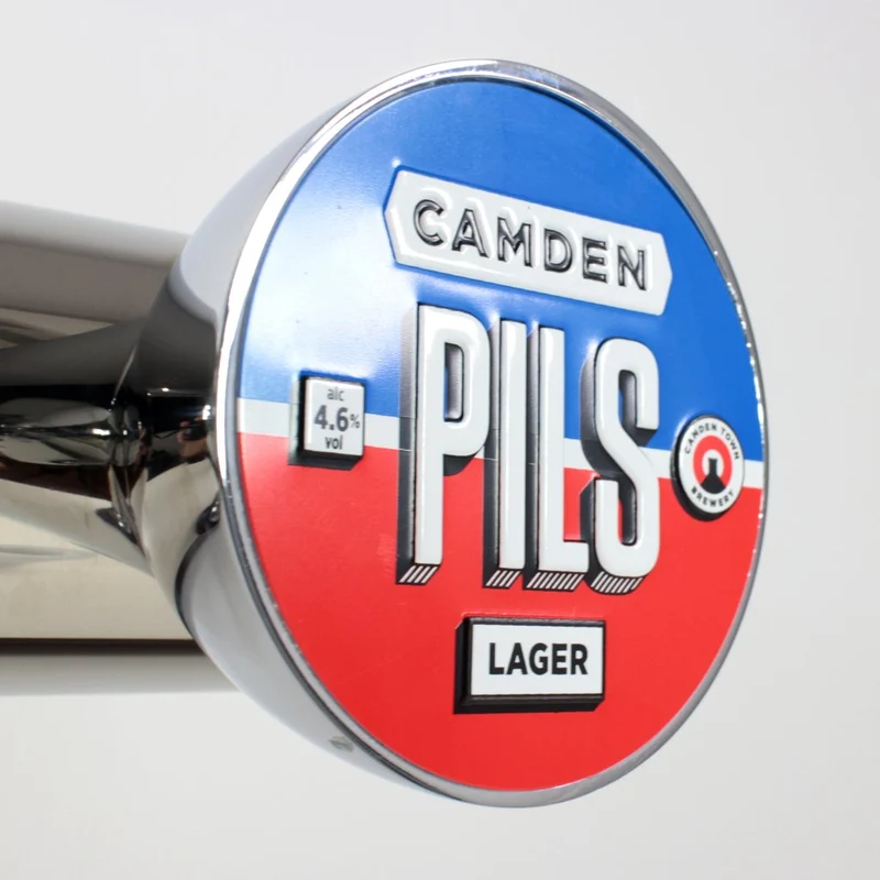 Cavaliers de pompe à bière métalliques et macaron publicitaire